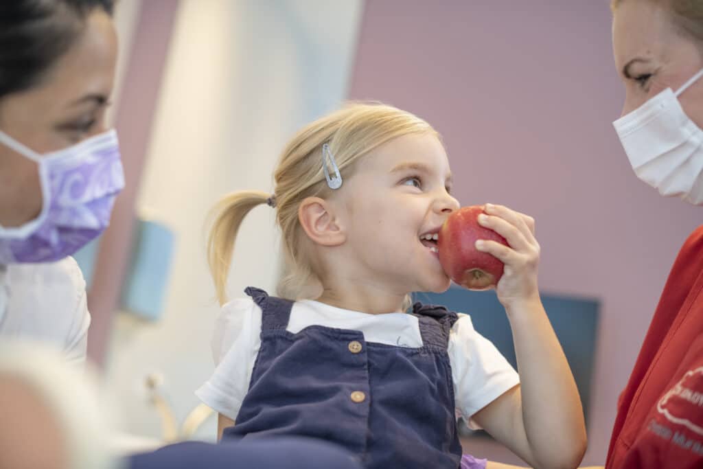 Kind beißt in einen Apfel