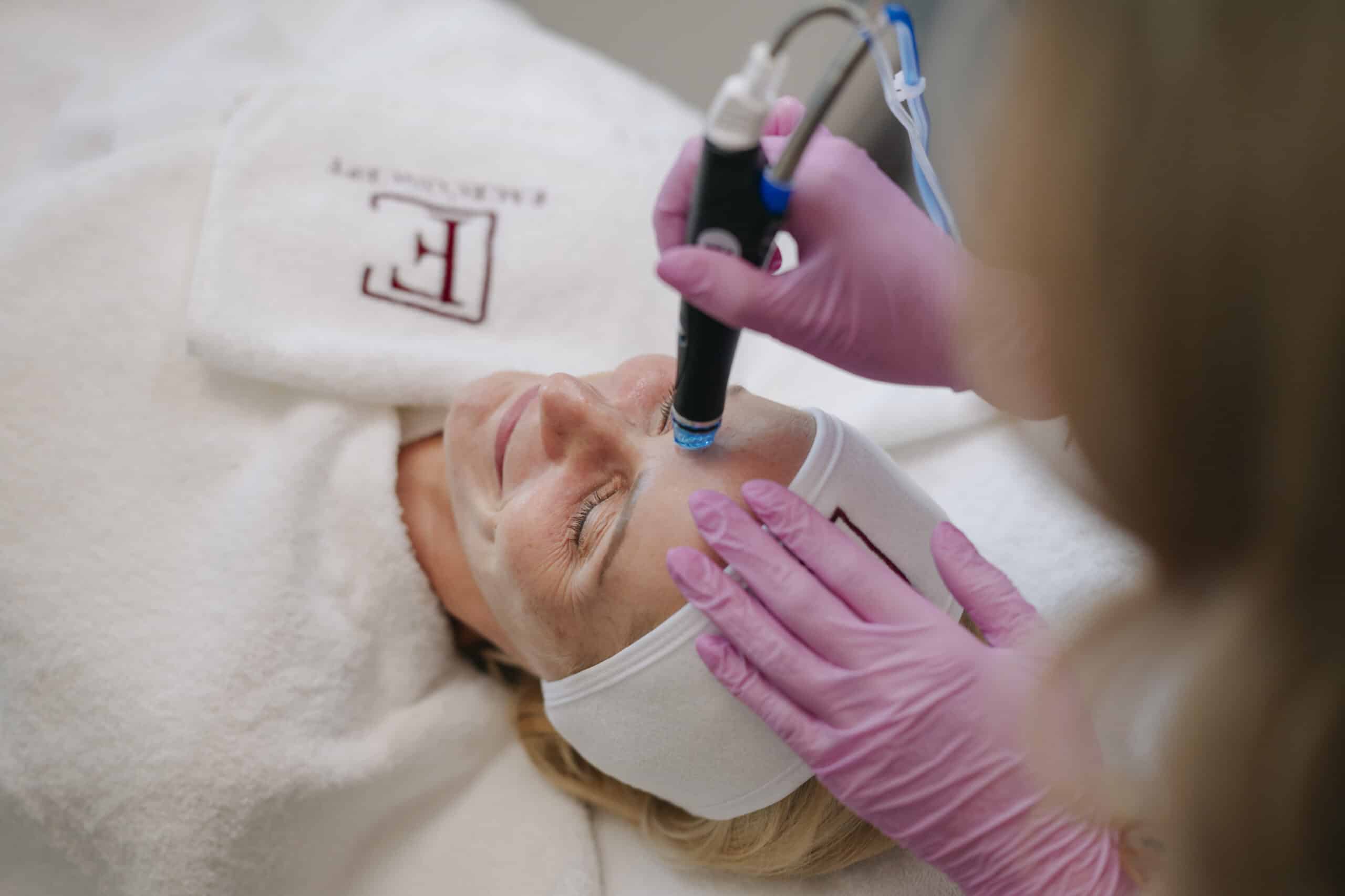 Hydrafacail Behandlung, die Patientin liegt entspannt auf der Liege und erhält seine Behandlung.