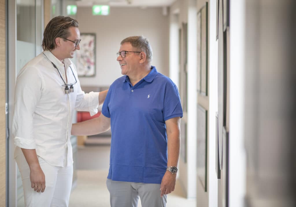 Implantologe erklärt Patienten die All-on-4-Behandlung.